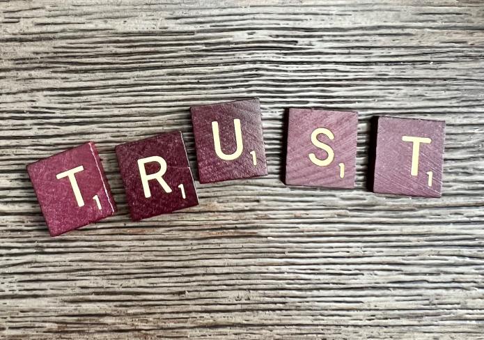 Scrabble tiles reading "Trust"